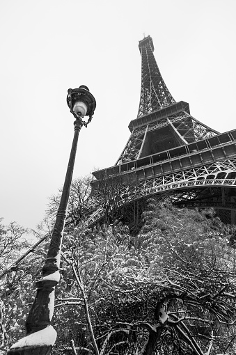 Eiffel tower and a lamppost under the snow in Paris, France