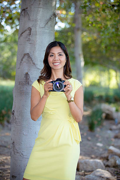 Smiling Asian Woman Holding Camera