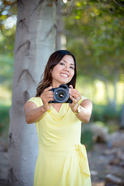istock Smiling Asian Woman Holding Camera 486560998