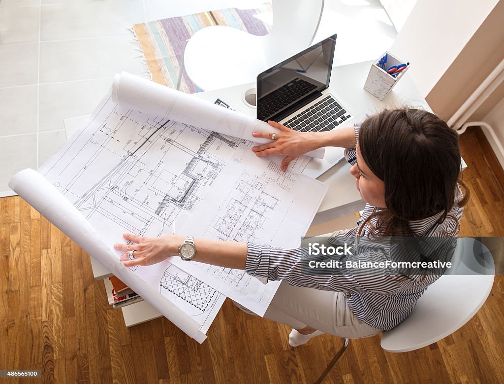 Female architect Female architect working at home.She looking at blueprint. Architecture Stock Photo