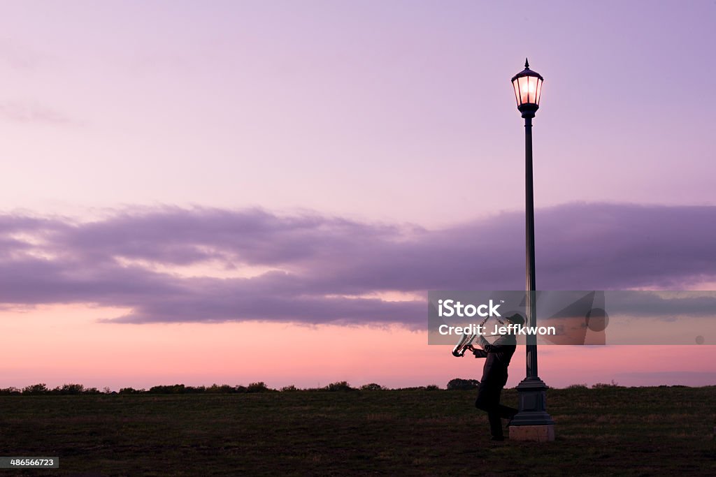 Eine person spielt eine Saxophon am Street Lampe - Lizenzfrei Abenddämmerung Stock-Foto