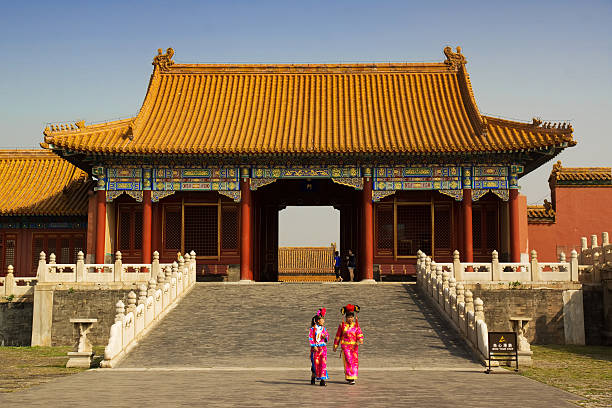 Beijing - Forbidden City Beijing, China - September 11, 2013: Two female tourists in rented traditional Chinese costumes walk past a gate in the Forbidden City. forbidden city beijing architecture chinese ethnicity stock pictures, royalty-free photos & images