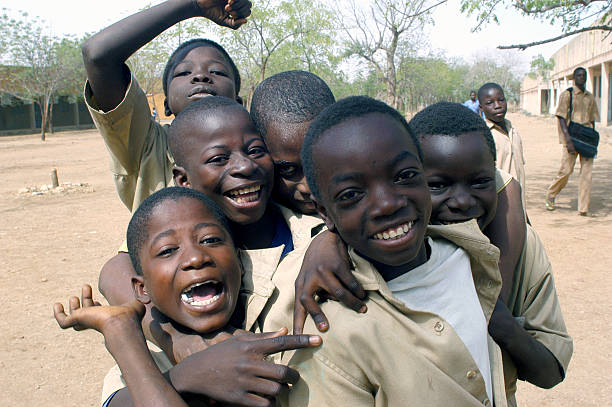 Poverty african kid village in Botswana, rural area, playing and hiding against the green door,
