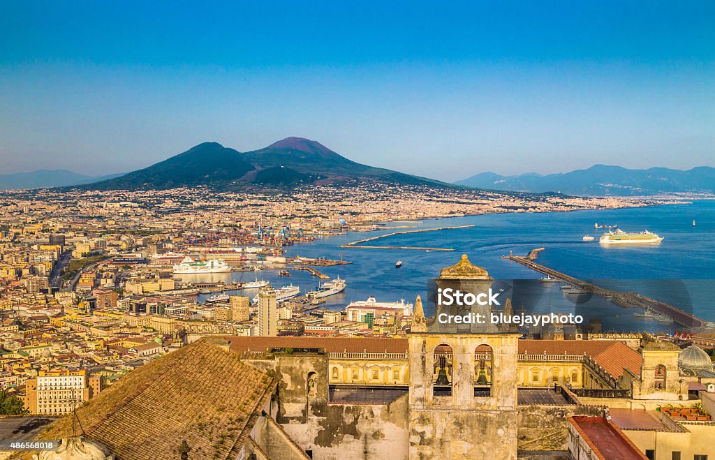 City of Naples with Mt. Vesuvius at sunset, Campania, Italy Panoramic view of the city of Napoli (Naples) with famous Mount Vesuvius in the background in golden evening light at sunset, Campania, Italy. Pompeii Stock Photo
