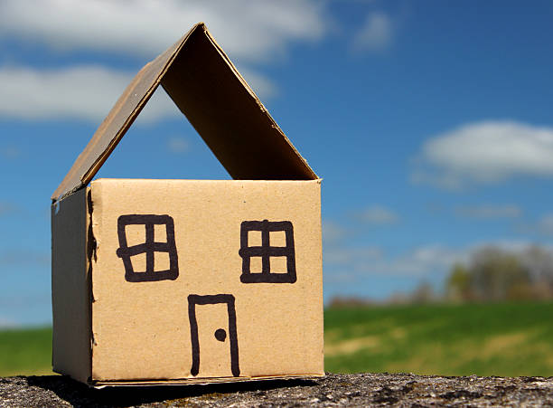 istock Image of cardboard dolls house, with field and blue sky 486568621