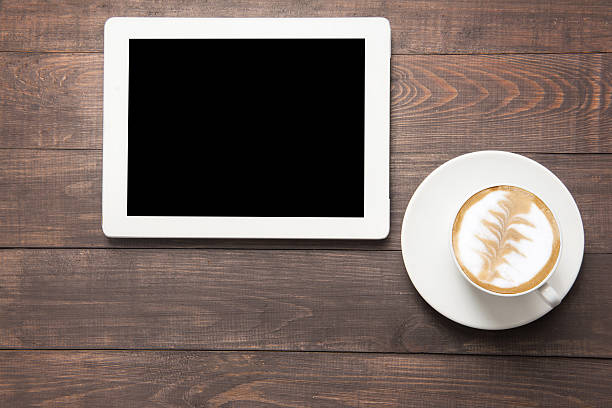 istock Digital tablet and coffee cup on wooden background 486569898