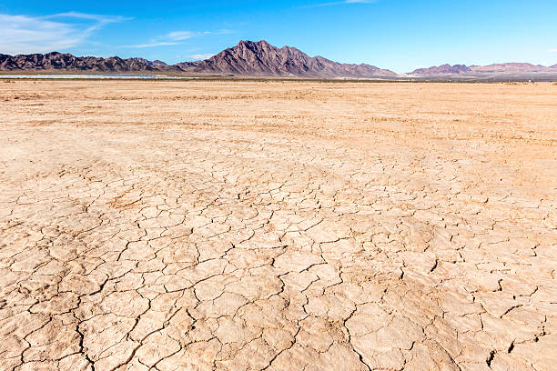 Dry lake bed in desert Cracked earth and deep blue skies, rocky mountains and alluvial fans in the panoramic image of the dry lake bed near Las Vegas, NV, California. Adobe RGB 1998 color profile. lake bed stock pictures, royalty-free photos & images