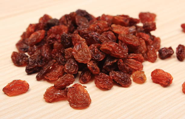 istock Brown raisins on wooden table, healthy eating 486572066