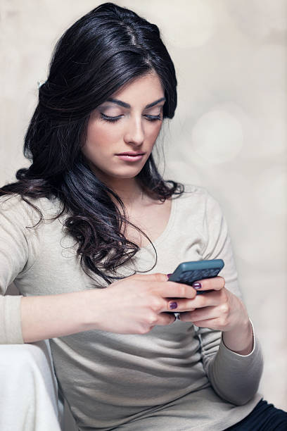 istock Beautiful young girl using a smartphone 486572124