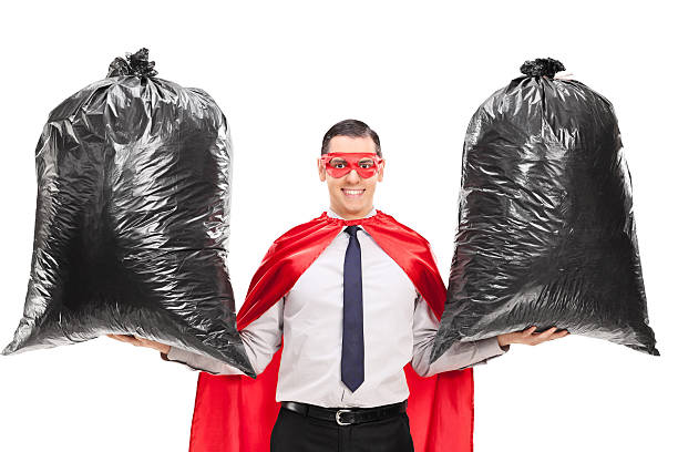 istock young superhero holding two trash bags 486572476