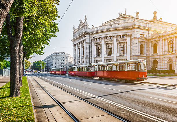 Wiener Ringstrasse with Burgtheater and tram at sunrise, Vienna, Austria Famous Wiener Ringstrasse with historic Burgtheater (Imperial Court Theatre) and traditional red electric tram at sunrise with retro vintage Instagram style filter effect in Vienna, Austria. burgtheater vienna stock pictures, royalty-free photos & images