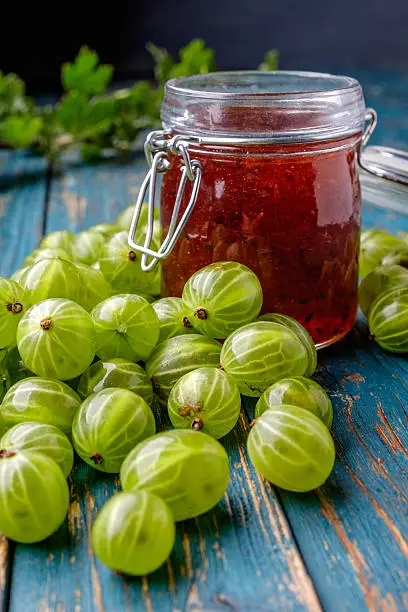 Jar of gooseberry jam on a wooden table
