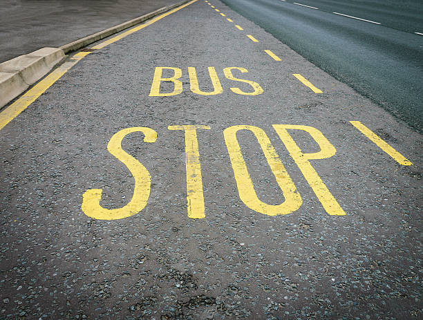 istock Yellow bus stop sign painted on the road asphalt 486576596