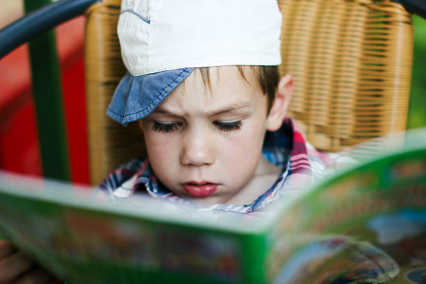 boy reading a magazine boy intently reading a children's magazine reading comic book stock pictures, royalty-free photos & images