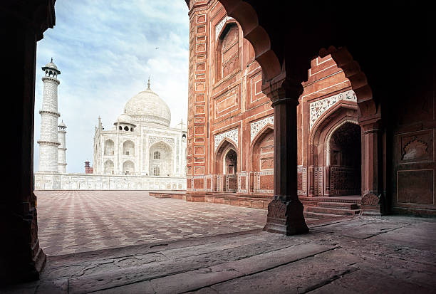 Taj Mahal tomb and mosque in the arch at blue sky in Agra, Uttar Pradesh, India