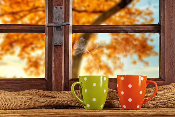 Vintage wooden window overlook autumn trees, shot from cottage interior with cups of tea