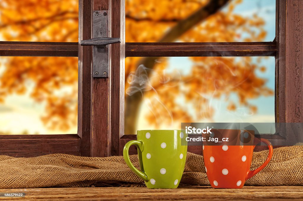 Vintage wooden window overlook autumn trees Vintage wooden window overlook autumn trees, shot from cottage interior with cups of tea 2015 Stock Photo