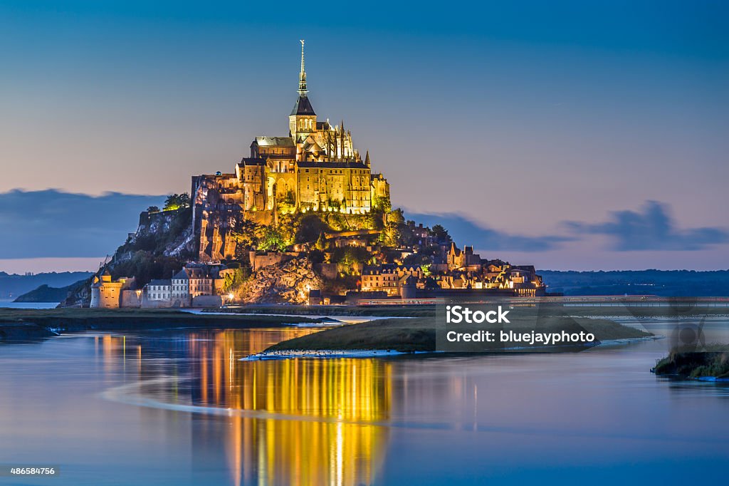 Mont Saint-Michel in twilight at dusk, Normandy, France Beautiful view of famous Le Mont Saint-Michel tidal island in beautiful twilight during blue hour at dusk, Normandy, northern France. Mont Saint-Michel Stock Photo