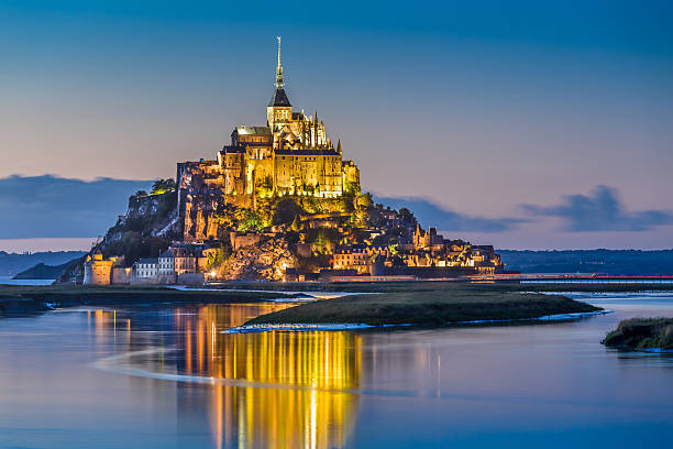 Mont Saint-Michel in twilight at dusk, Normandy, France Beautiful view of famous Le Mont Saint-Michel tidal island in beautiful twilight during blue hour at dusk, Normandy, northern France. brittany france stock pictures, royalty-free photos & images