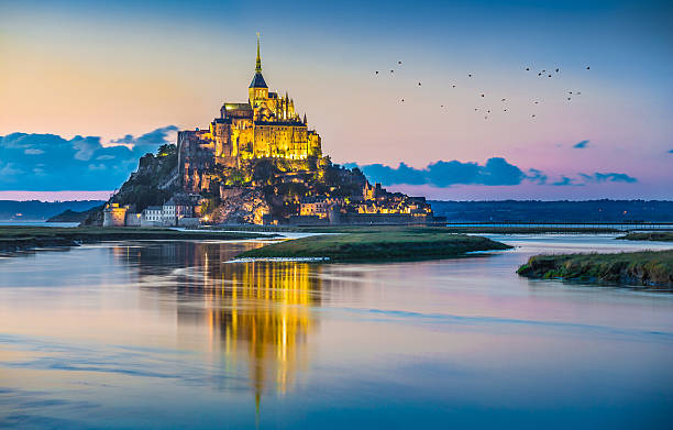 Mont Saint-Michel in twilight at dusk, Normandy, France Beautiful view of famous Le Mont Saint-Michel tidal island in beautiful twilight during blue hour at dusk, Normandy, northern France. marazion photos stock pictures, royalty-free photos & images
