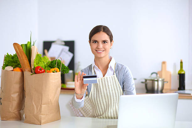 istock Smiling woman online shopping using computer and credit card in 486594734
