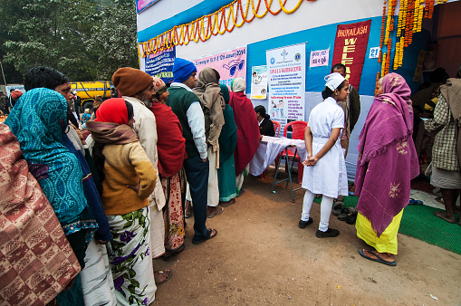 Kolkata, India - January 12, 2014: Hindu devotees queing up for medicine at emergency medical camp at Babughat transit Camp, Kolkata. Every year Hindu devotees from all over the country visits Gangasar and stays for some days in Babughat transit camp, Kolkata. 