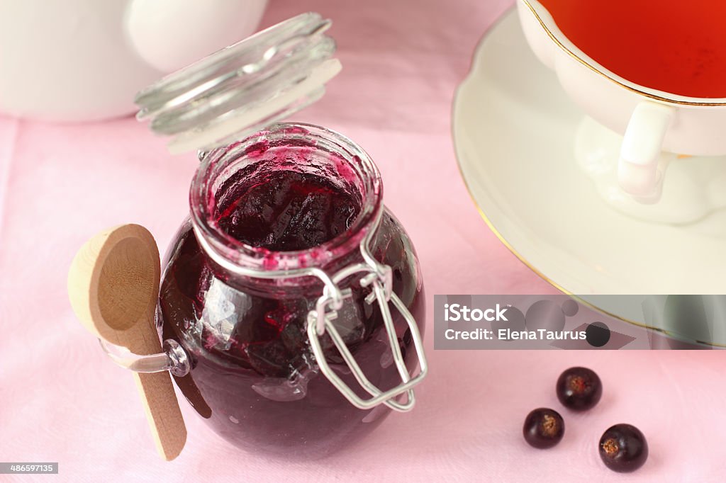 Black currant jam in glass jar with tea Black Currant Stock Photo