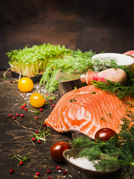 istock Raw salmon fillet with fresh herbs and tomatoes 486600342