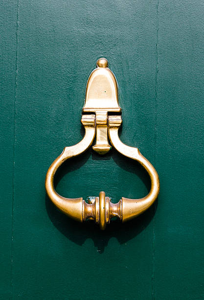 istock Gold Colored Door knock on a Green Door 486600965
