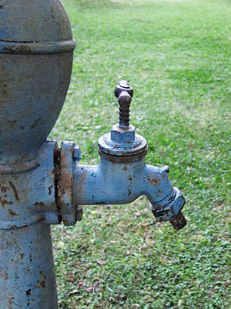 Close up image of the fautes of an old watwr pump