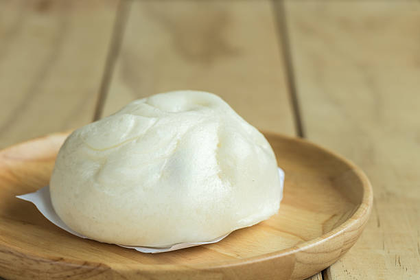 istock White Steamed buns on wooden tray 486602304
