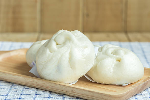 istock White Steamed buns on wooden tray 486602548