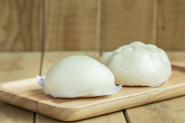 istock White Steamed buns on wooden tray 486602702