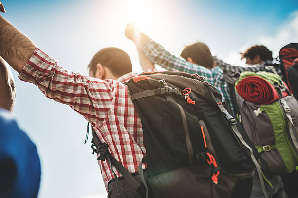istock group of people standing on the mountain with arm raised 486603837