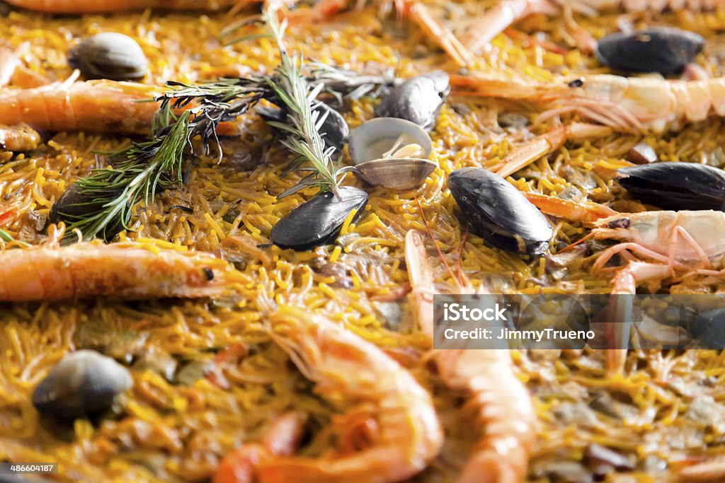 Spanish fideua Noodles Spanish paella. Shallow DOF, focus on center and backgroound. Clam - Seafood Stock Photo