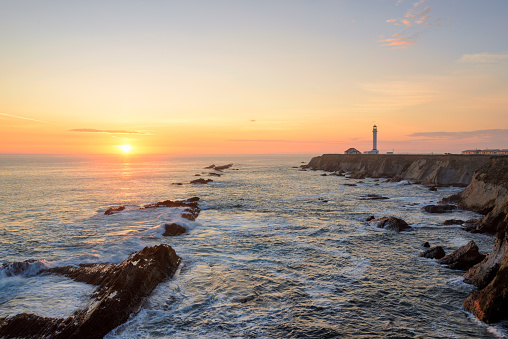 Seascape at sunset. Point Arena Lighthouse on the coast.