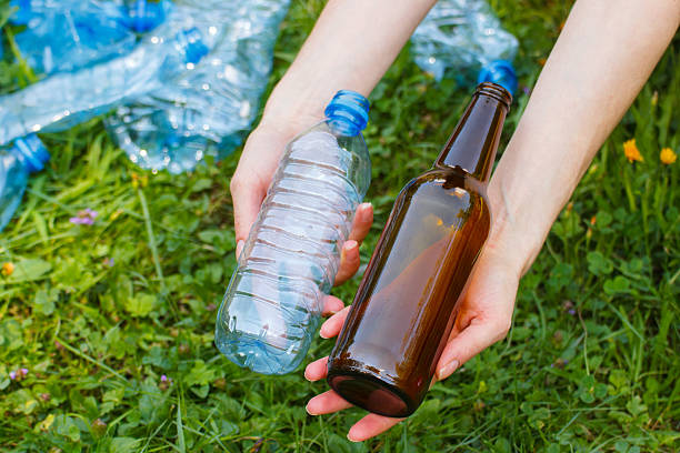 istock Plastic and glass bottle in hand, littering of environment 486609896