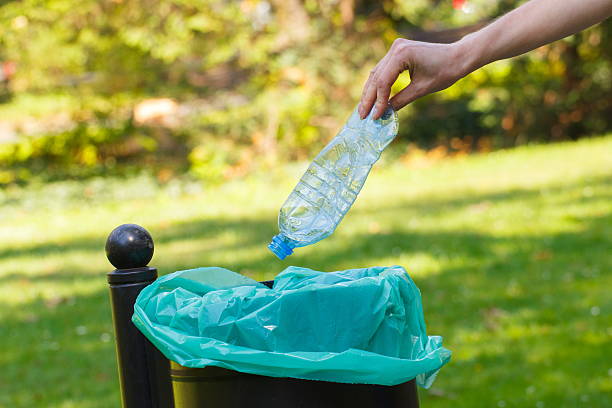istock Hand of woman throwing plastic bottle into recycling bin 486611142