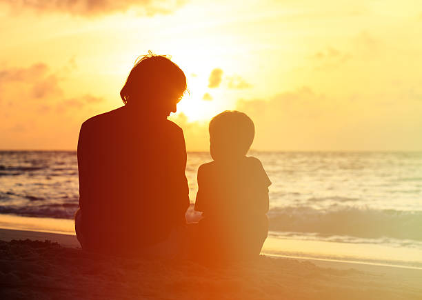 istock father and little son looking at sunset on beach 486615728