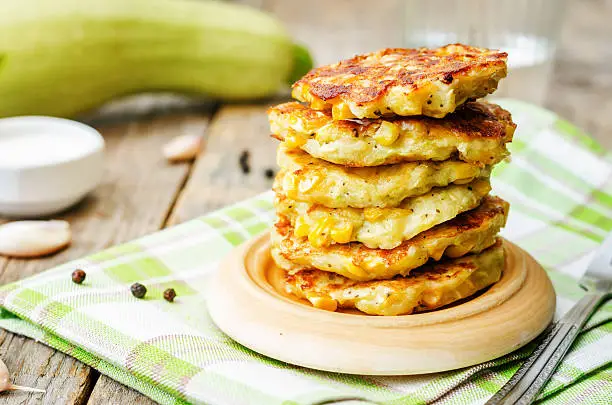 zucchini corn fritters on a dark wood background. the toning. selective focus