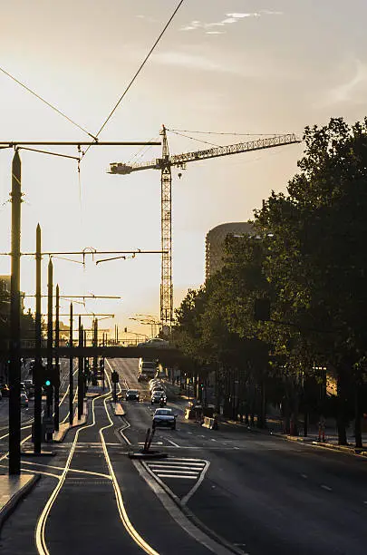 Cityscape at sunset with crane and tramline