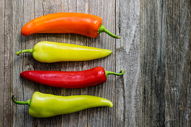 Four Colorful Peppers on a Table stock photo