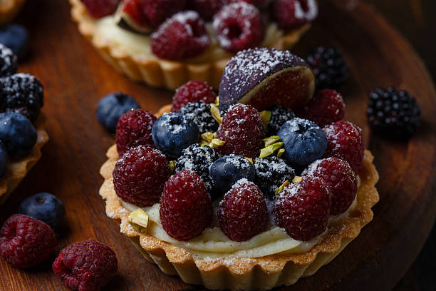 istock Tartlets with fresh berries on wooden background 486616602