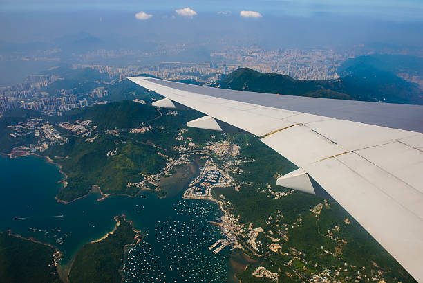 istock Airplane flying over hong kong 486621056
