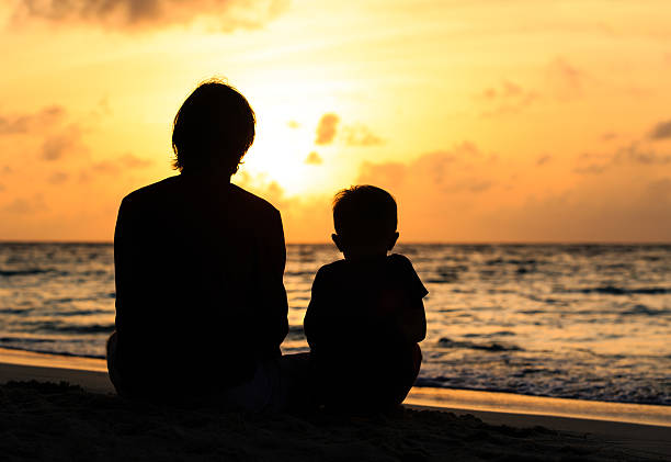 istock father and little son looking at sunset on beach 486621818