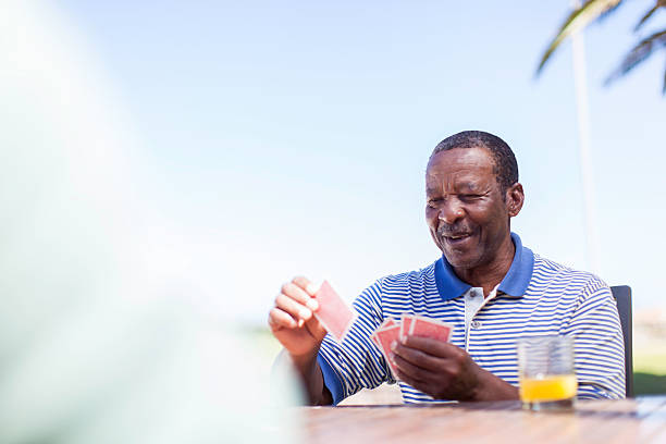 istock African senior playing a cards 486624315