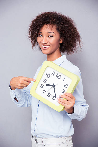 istock Happy afro american woman standing with clock 486627534