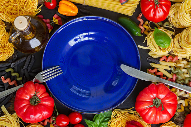 istock Raw pasta with ingridients and blue plate 486633380