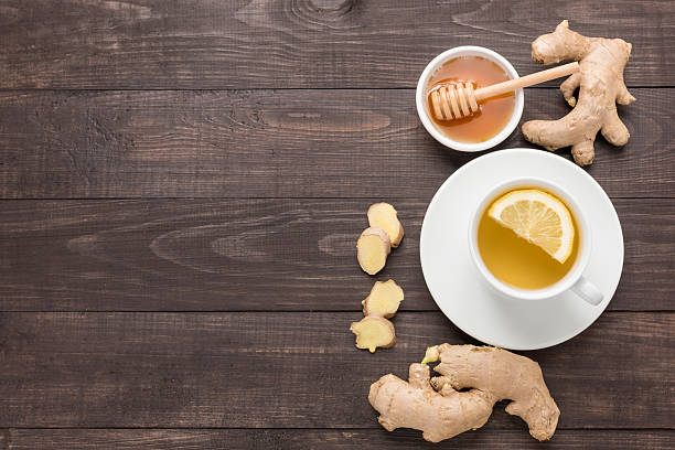 istock Cup of ginger tea with lemon and honey on table. 486639036