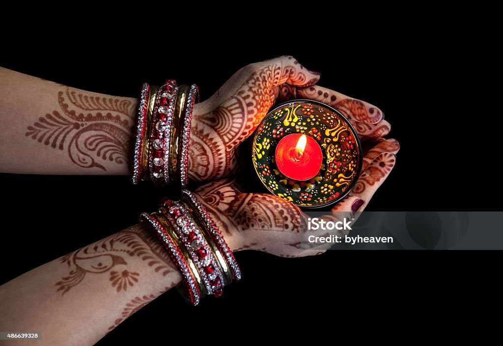 Diwali celebration Woman hands with henna holding candle isolated on black background with clipping path Diwali Stock Photo